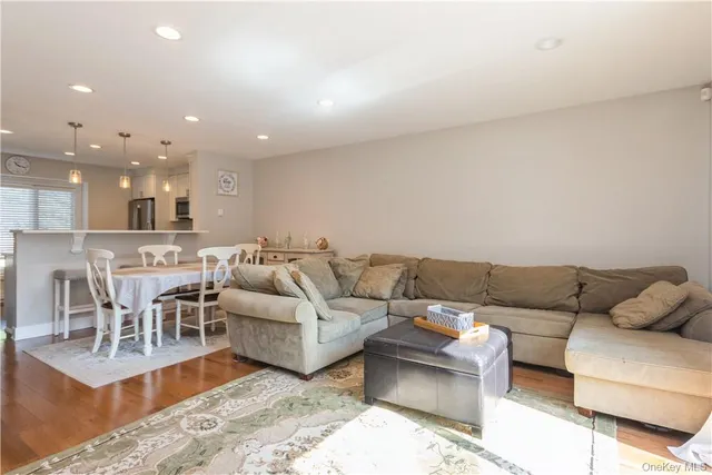a living room with furniture and a view of kitchen