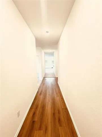 a view of a hallway with wooden floor