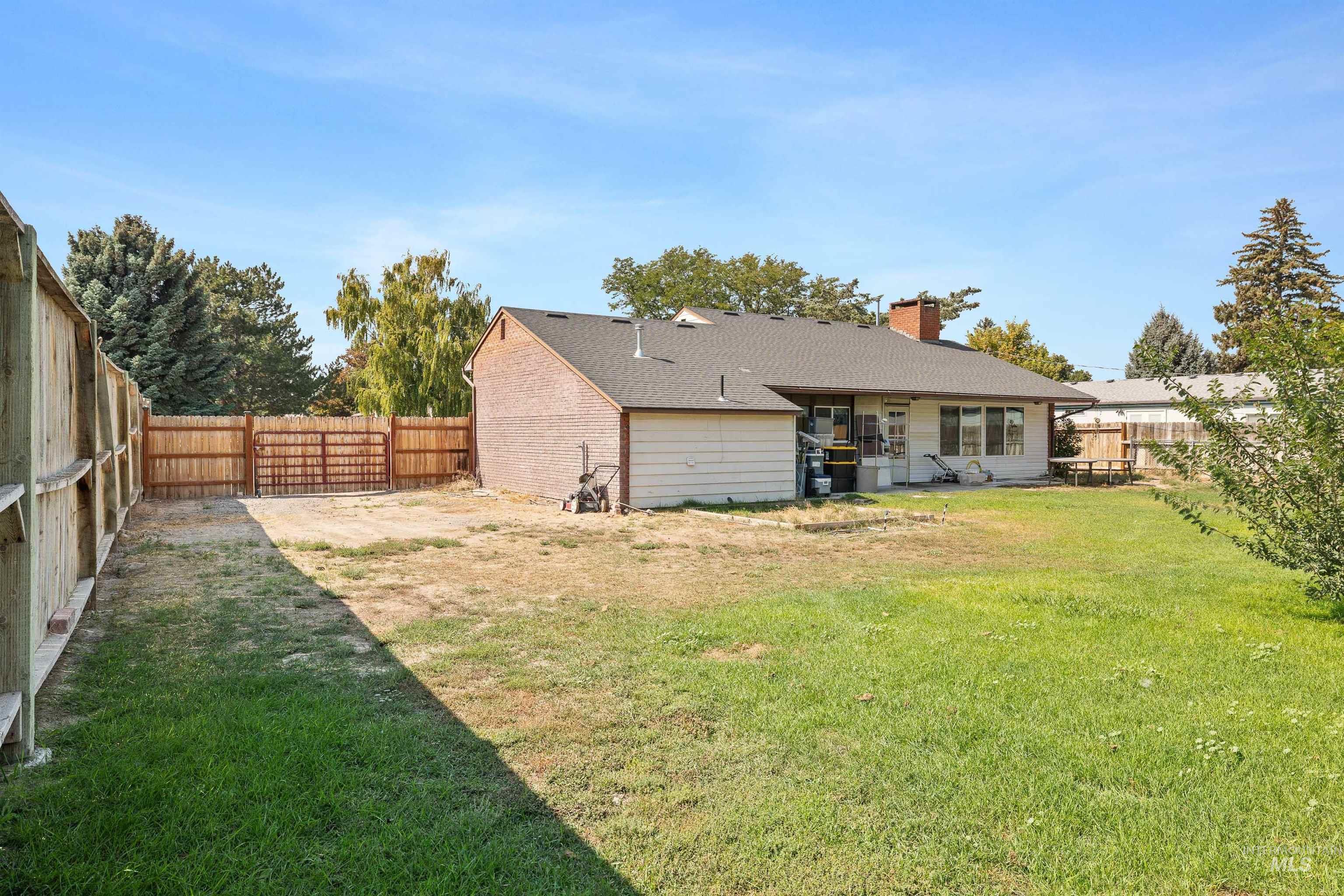 817 Union Avenue Filer, ID 83328 - Photo 26 of 37 Rear view of property with a fenced backyard, a chimney, a shingled roof, and a patio area