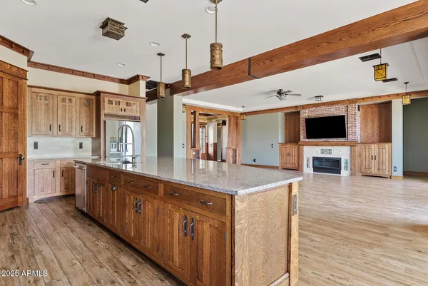 a large kitchen with stainless steel appliances a large counter top a stove and a wooden floors