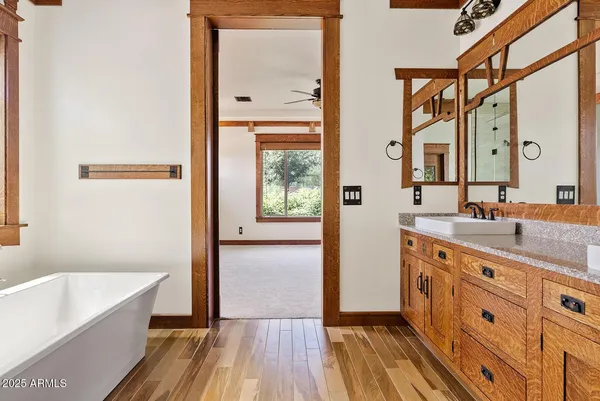 a bathroom with a granite countertop sink a mirror and a bathtub