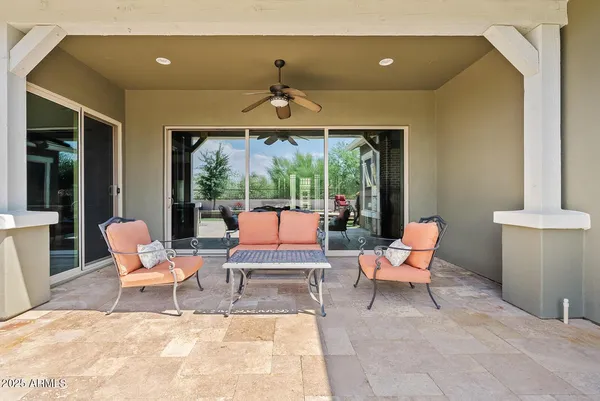 a view of a patio with table and chairs with plants and wooden fence