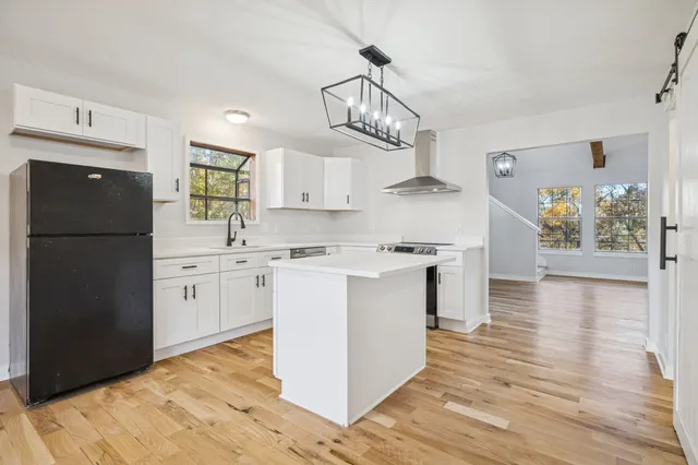 a kitchen with cabinets wooden floor and a window