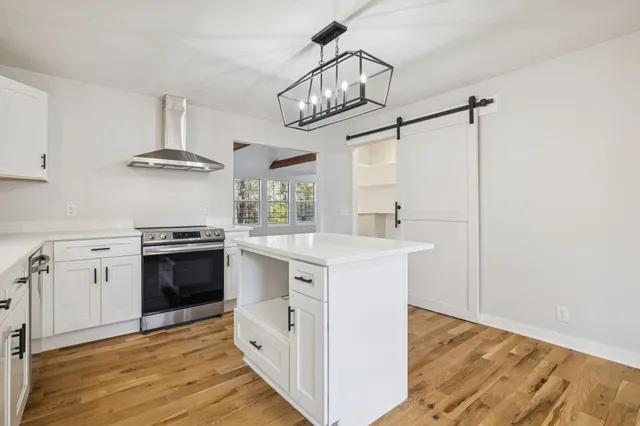 a view of empty room with wooden floor and refrigerator