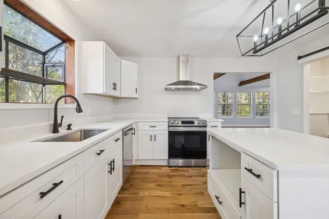 a view of a room with wooden floor and a window