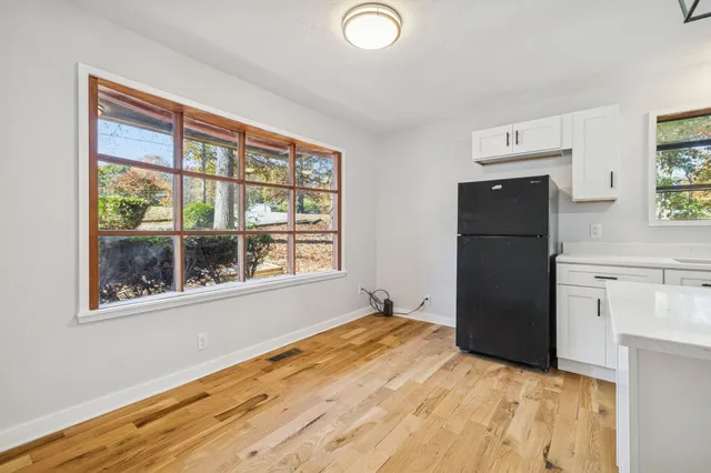 a view of an empty room with window and front door