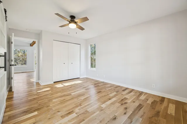 a view of a hallway with wooden floor and staircase