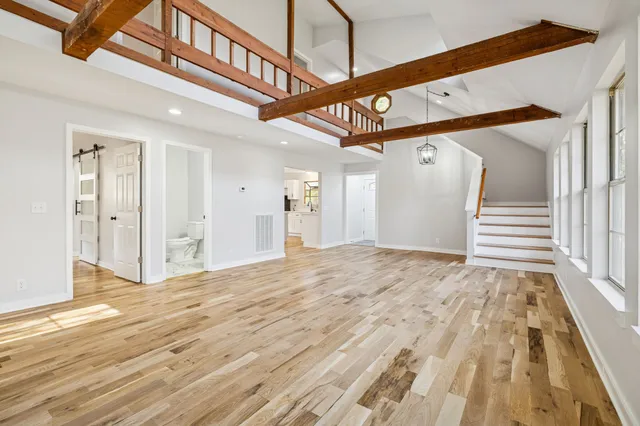 a kitchen with stainless steel appliances a white stove top oven and a sink with wooden floor