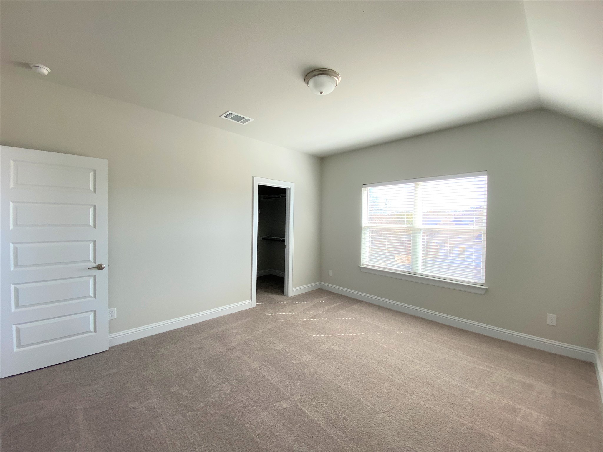 600 C-Bar Ranch Trail, Unit 105 Cedar Park, TX 78613 - Photo 8 of 12 Unfurnished bedroom with a walk in closet, light colored carpet, and vaulted ceiling