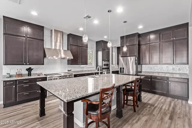 a kitchen with granite countertop kitchen island a sink stove and refrigerator