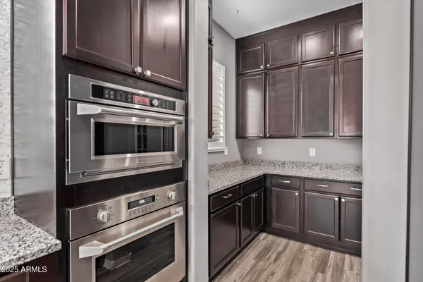 a kitchen with granite countertop a sink stainless steel appliances and cabinets