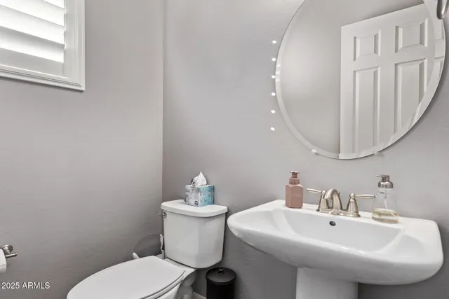 a bedroom with a large bed chandelier and a window