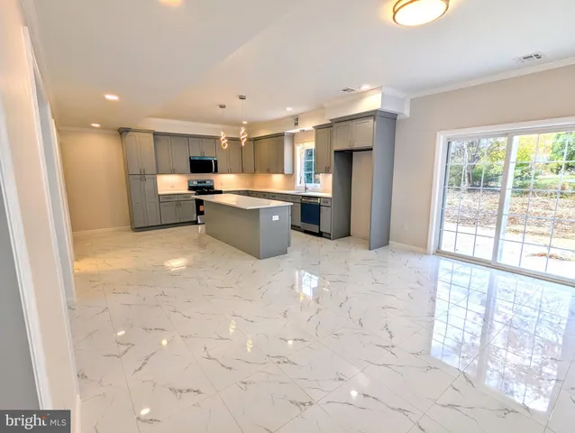 a open kitchen with kitchen island a large window cabinets and stainless steel appliances