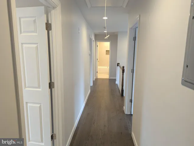 a view of a hallway with wooden floor and entryway