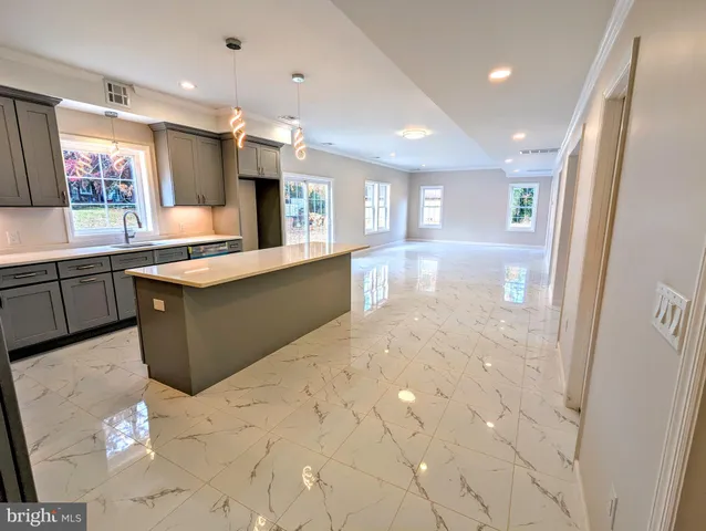 a large kitchen with stainless steel appliances kitchen island granite countertop a sink and cabinets