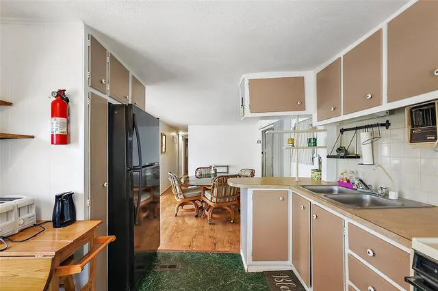 a kitchen with stainless steel appliances granite countertop a refrigerator and a stove top oven