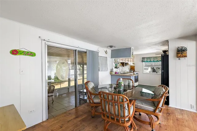 a view of a dining room with furniture a chandelier and wooden floor
