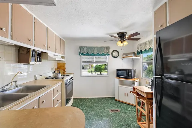 a kitchen with granite countertop a sink stainless steel appliances and cabinets