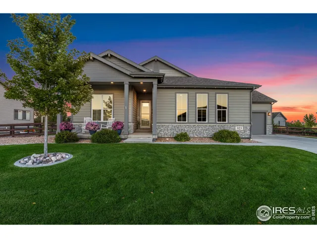 a front view of a house with a garden and yard