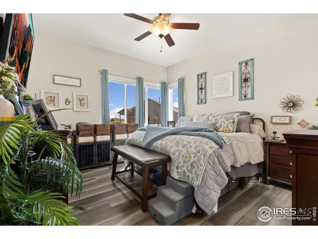 a spacious bedroom with a bed a couch and a chandelier
