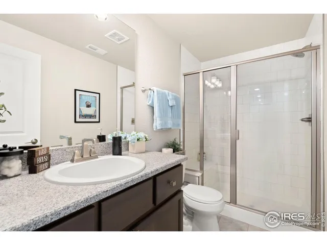 a bathroom with a granite countertop sink toilet a large mirror a shower and a bathtub