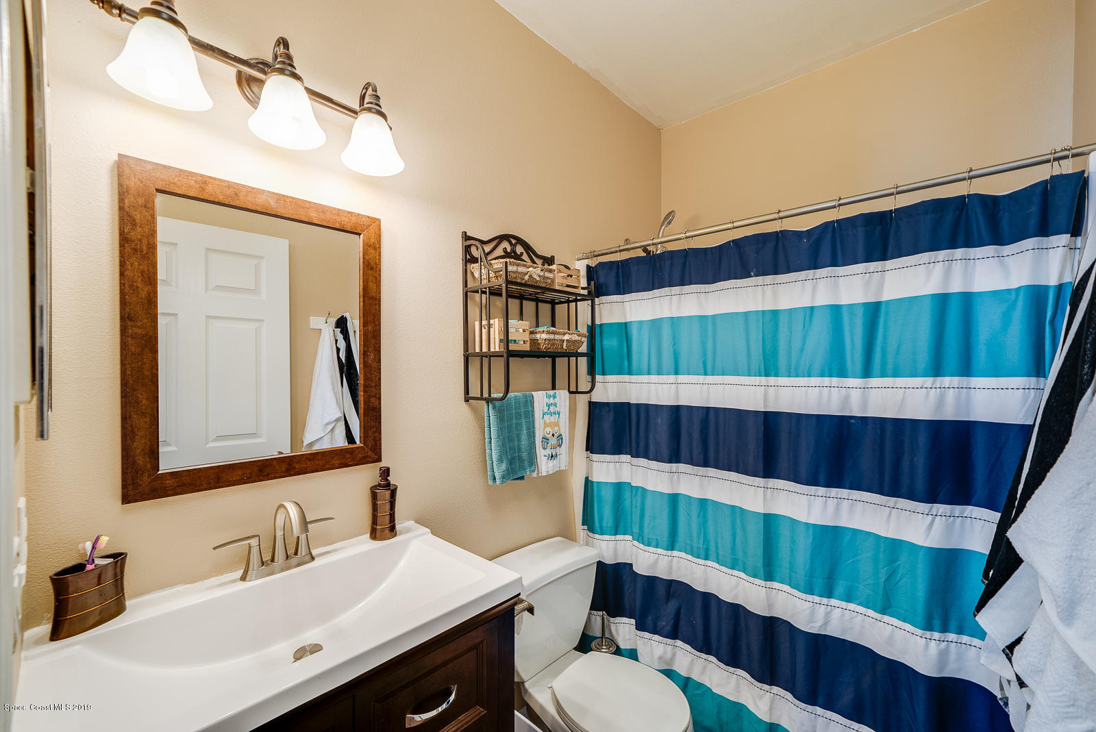 155 Bluff Terrace Melbourne, FL 32901 - Photo 13 of 20 a bathroom with a sink a toilet and shower curtain