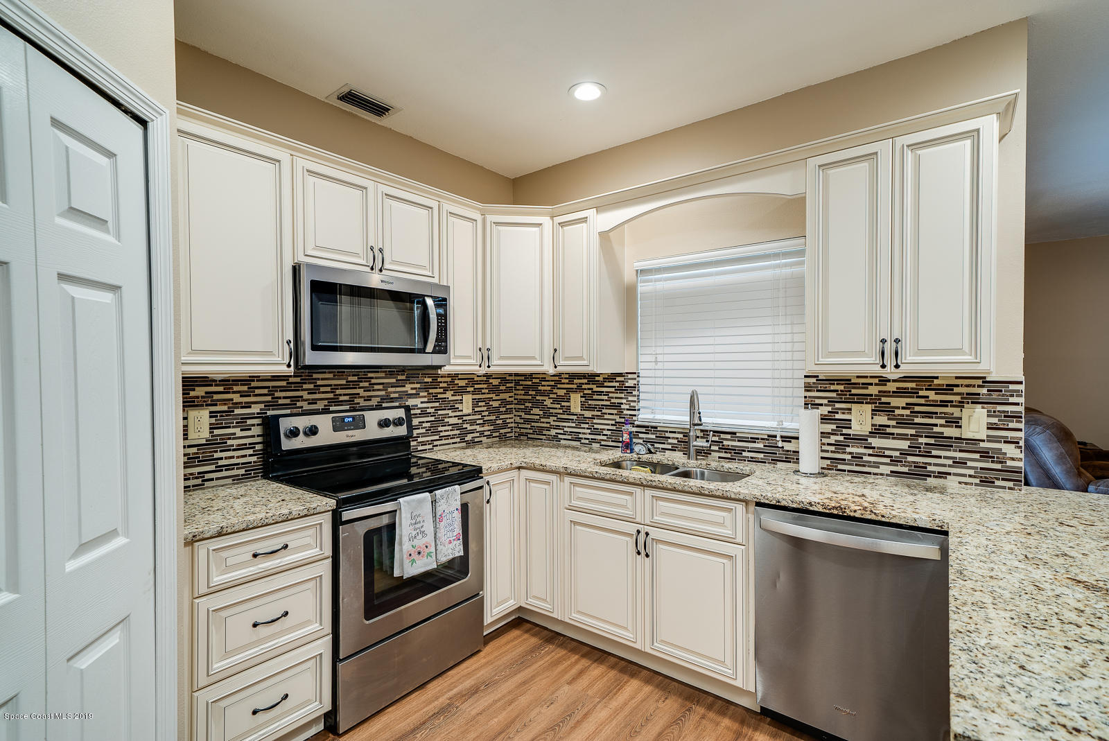 155 Bluff Terrace Melbourne, FL 32901 - Photo 3 of 20 a kitchen with cabinets stainless steel appliances a sink and wooden floor