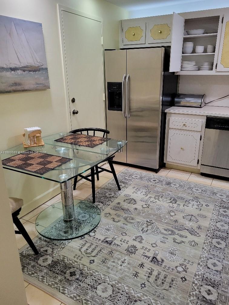 1833 South Ocean Drive, Unit 307 Hallandale Beach, FL 33009 - Photo 17 of 19 a kitchen with a table chairs and a refrigerator