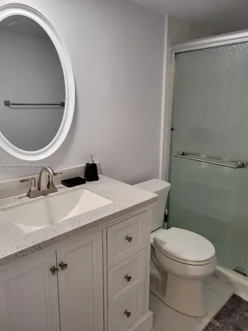 a bathroom with a shower a toilet and a sink