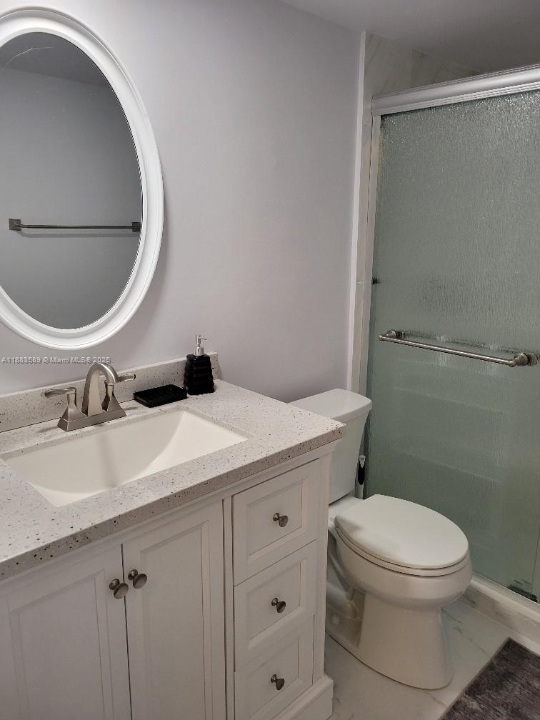1833 South Ocean Drive, Unit 307 Hallandale Beach, FL 33009 - Photo 10 of 19 a bathroom with a granite countertop toilet sink and mirror
