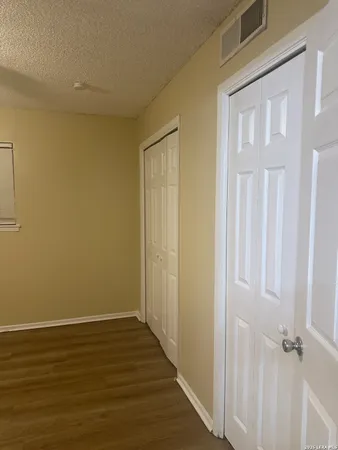 a view of an empty room with wooden floor