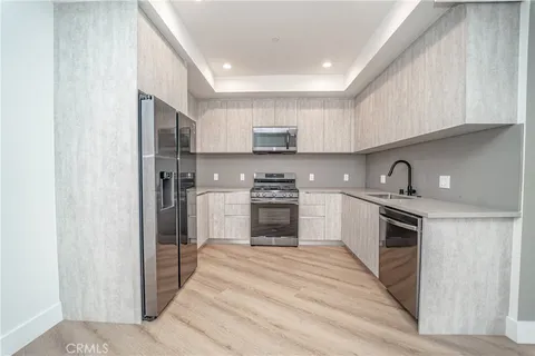 a kitchen with stainless steel appliances granite countertop a refrigerator sink and stove