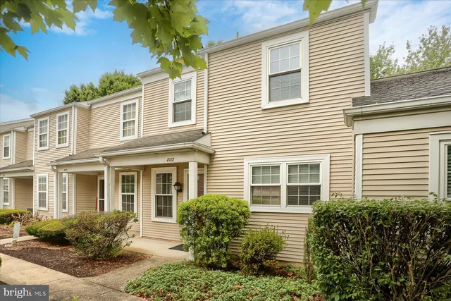 a view of a house with potted plants and a table and chair
