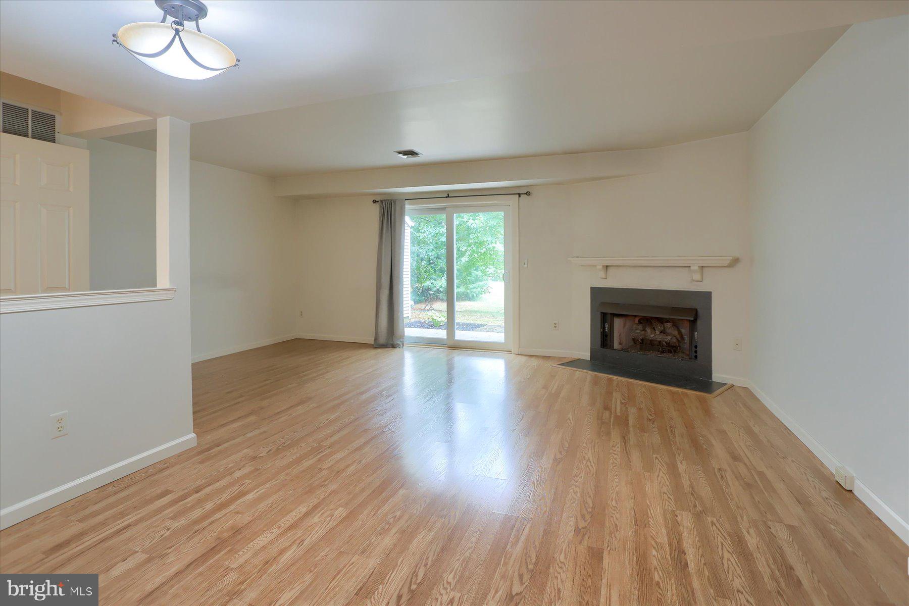 802 Cambridge Court Palmyra, PA 17078 - Photo 9 of 32 an empty room with wooden floor fireplace and windows