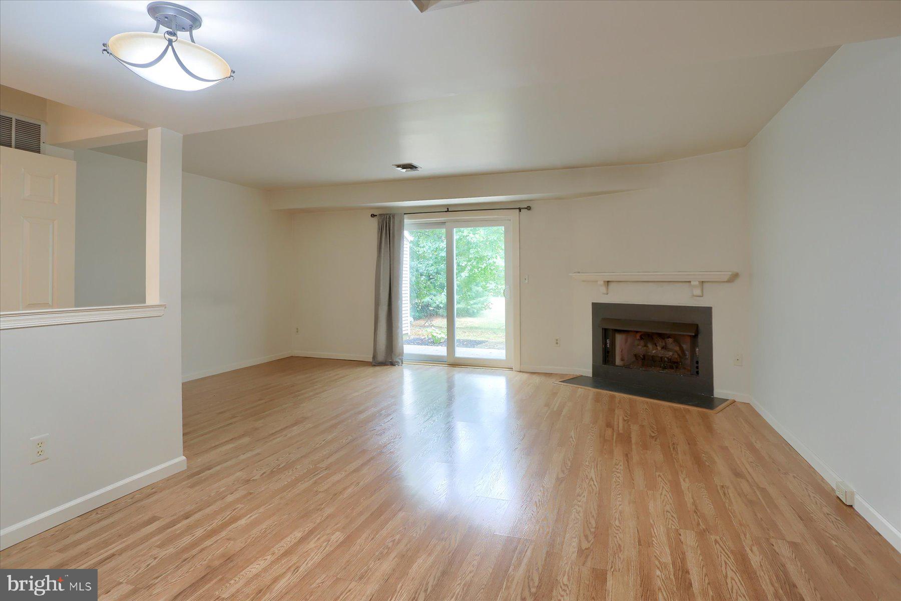 802 Cambridge Court Palmyra, PA 17078 - Photo 10 of 32 an empty room with wooden floor fireplace and windows