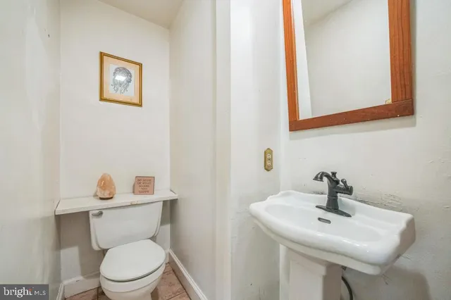 a bathroom with a toilet a sink and mirror