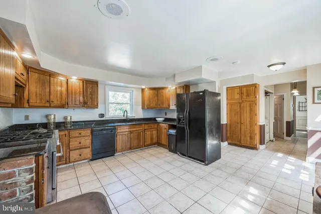 a kitchen with stainless steel appliances granite countertop a refrigerator stove top oven and sink