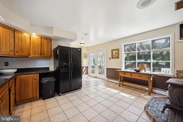a kitchen with granite countertop a refrigerator and wooden cabinets
