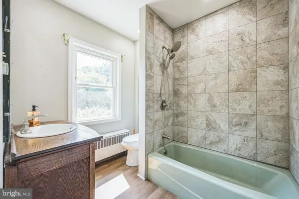 a bathroom with a bathtub a sink a toilet and a shower