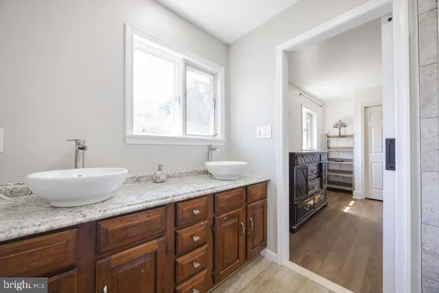 a en suite bathroom with a granite countertop sink and mirror
