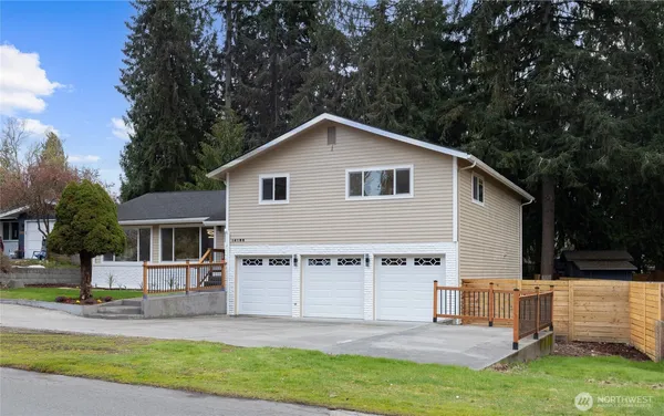 a view of a house with a yard and large tree