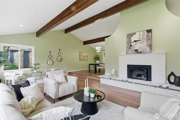 a living room with furniture a fireplace and a large mirror