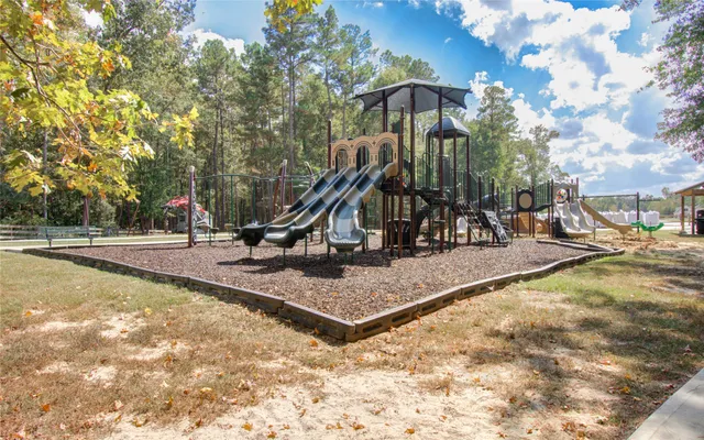 a view of a swimming pool with sitting area and slide
