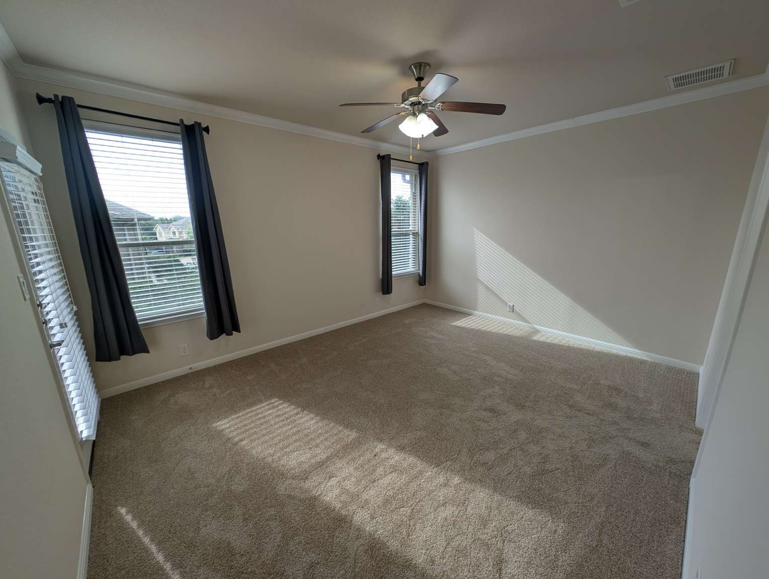 7301 Bandera Ranch Trail, Unit A Austin, TX 78750 - Photo 16 of 20 Sun-filled room featuring plush carpeting and essential crown molding details, perfect for a cozy retreat.