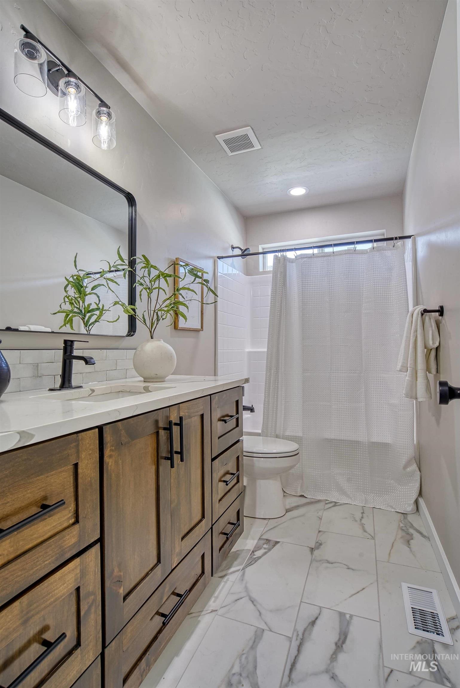 960 Campbell Street Vale, OR 97918 - Photo 17 of 49 Bathroom featuring a wood-finish vanity with dark hardware, a white countertop, and a rectangular undermount sink
