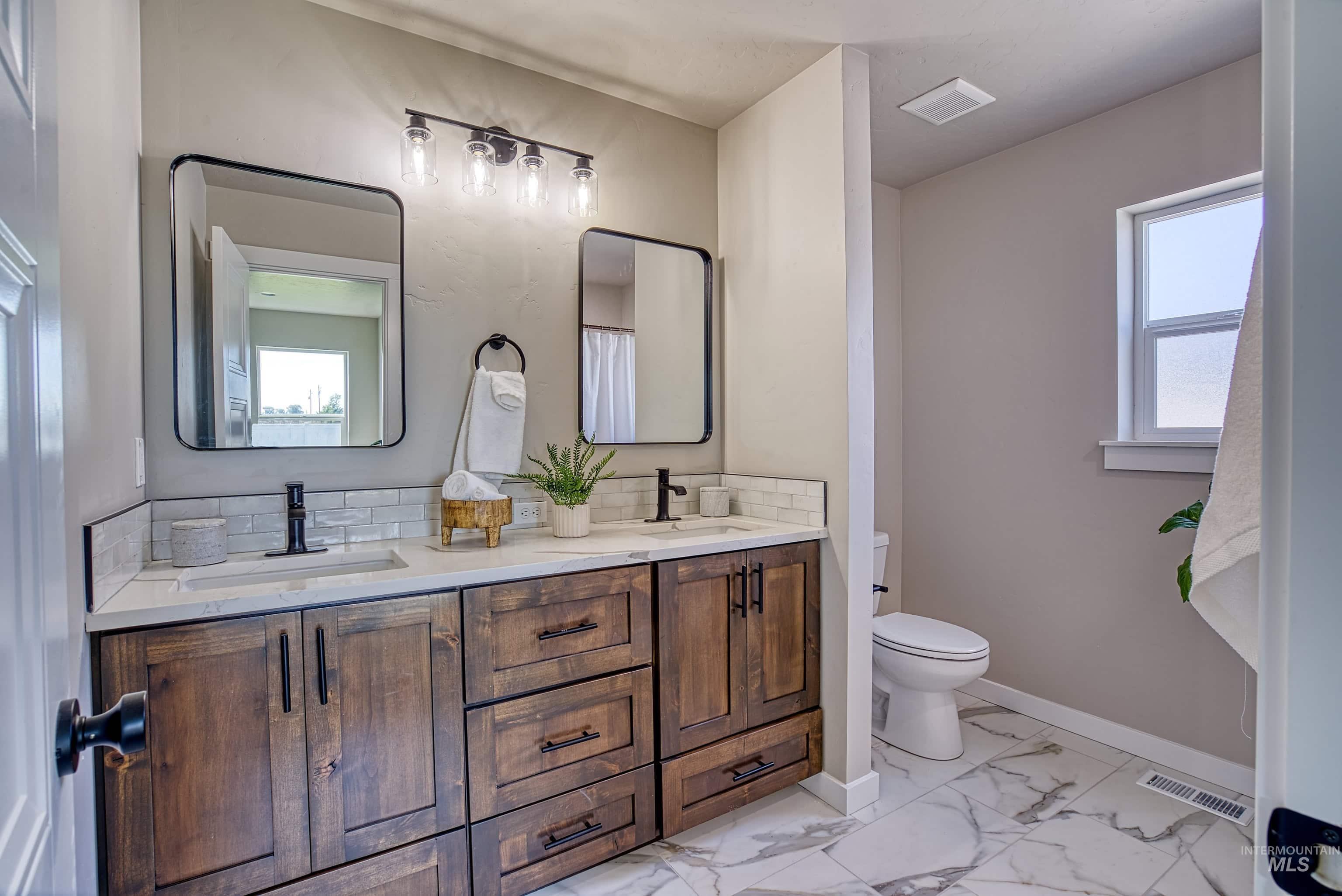 960 Campbell Street Vale, OR 97918 - Photo 23 of 49 Bathroom featuring a dual-sink vanity with wood-finish cabinetry, white stone countertops, and rectangular undermount sinks