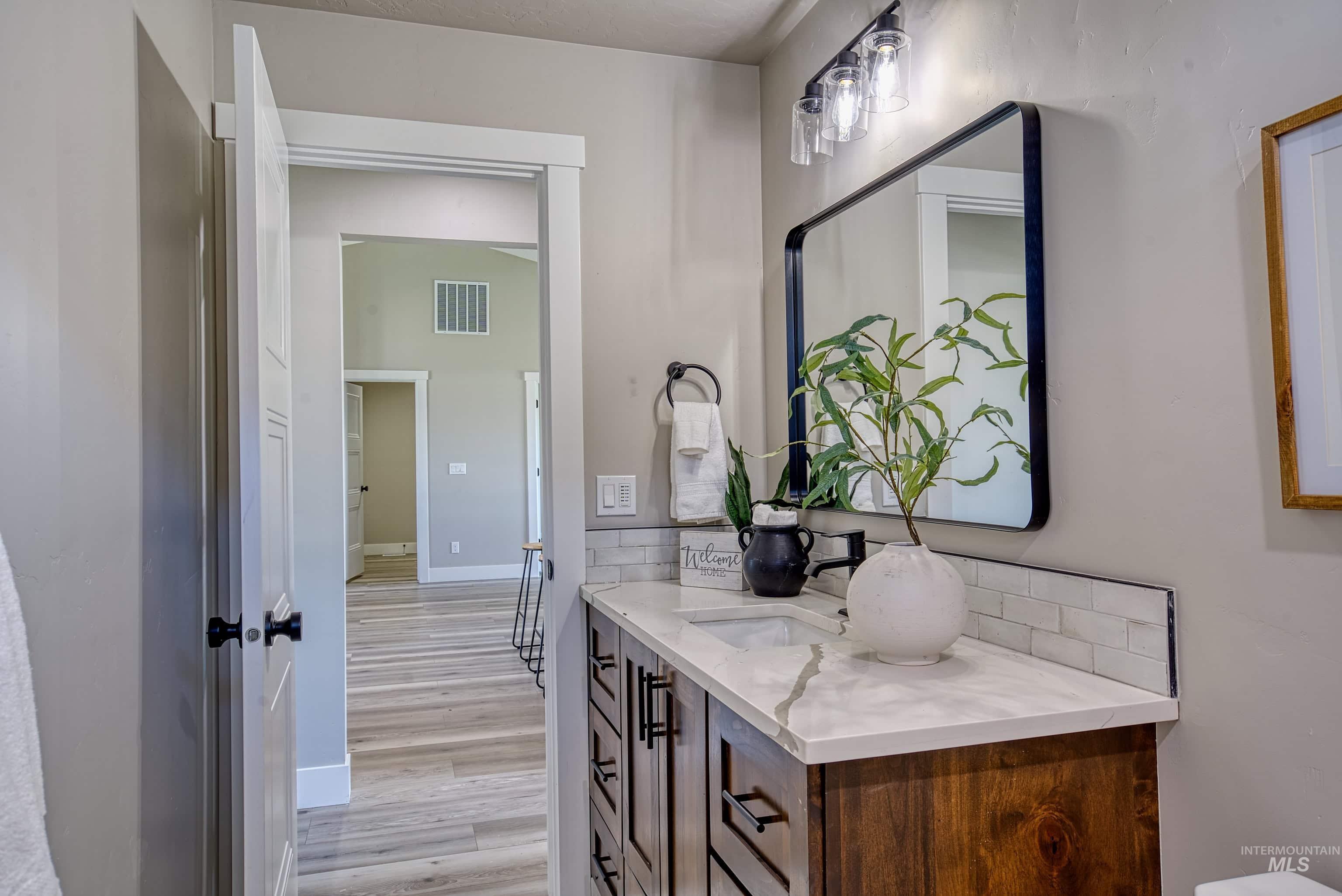 960 Campbell Street Vale, OR 97918 - Photo 25 of 49 Bathroom vanity featuring a wood-finish cabinet, white countertop, and subway tile backsplash