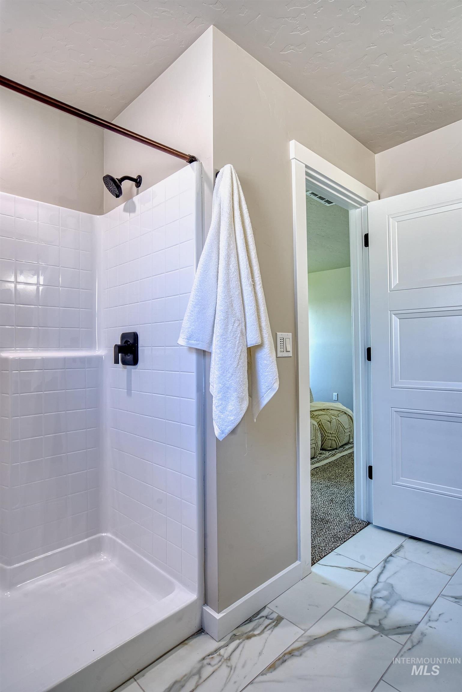 960 Campbell Street Vale, OR 97918 - Photo 26 of 49 Bathroom with a white tiled shower featuring a matte black showerhead and control