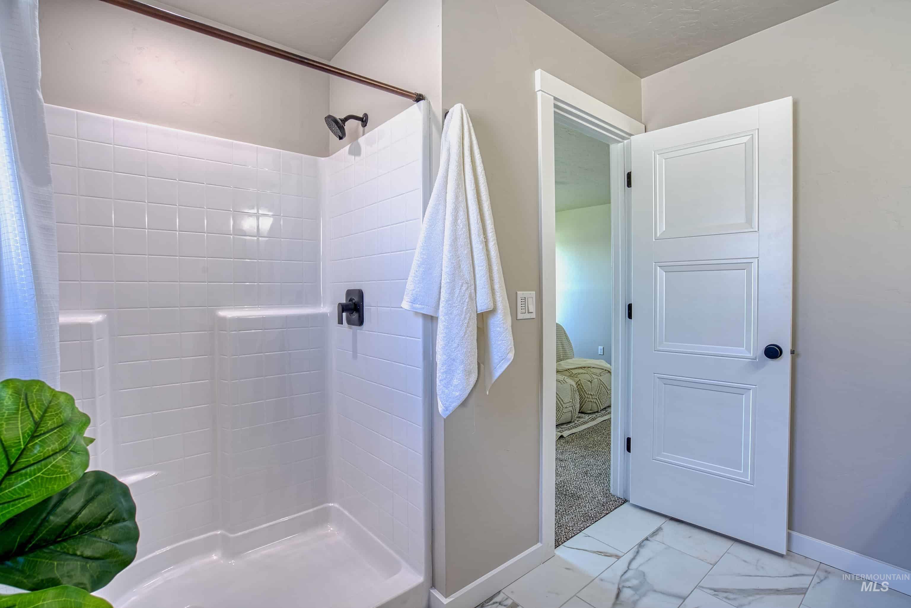 960 Campbell Street Vale, OR 97918 - Photo 30 of 49 Shower with white tile surround, integrated shelving, and matte black fixtures