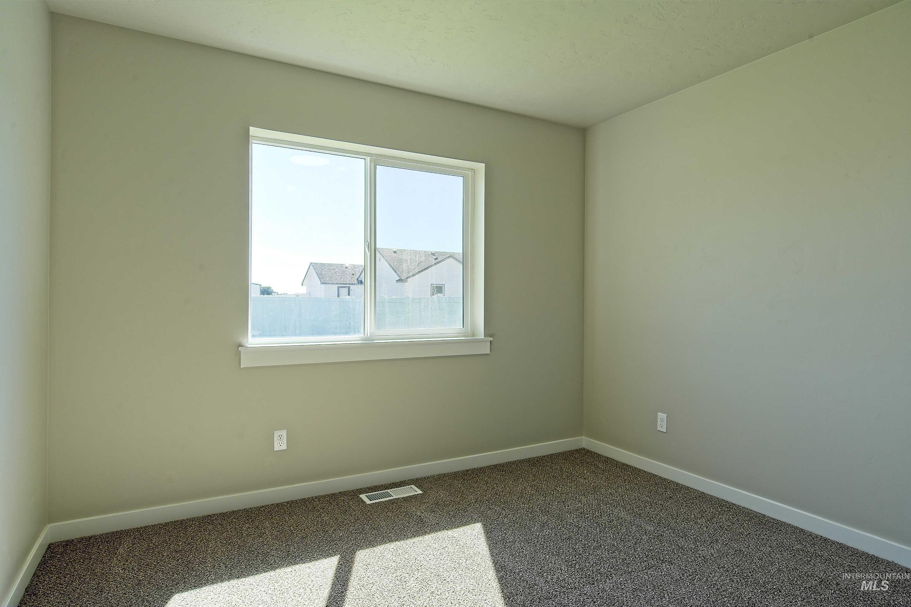 960 Campbell Street Vale, OR 97918 - Photo 32 of 49 Carpeted interior room featuring a large window, light-colored walls, and white trim